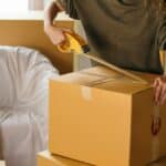 A woman is packing her things in a box.