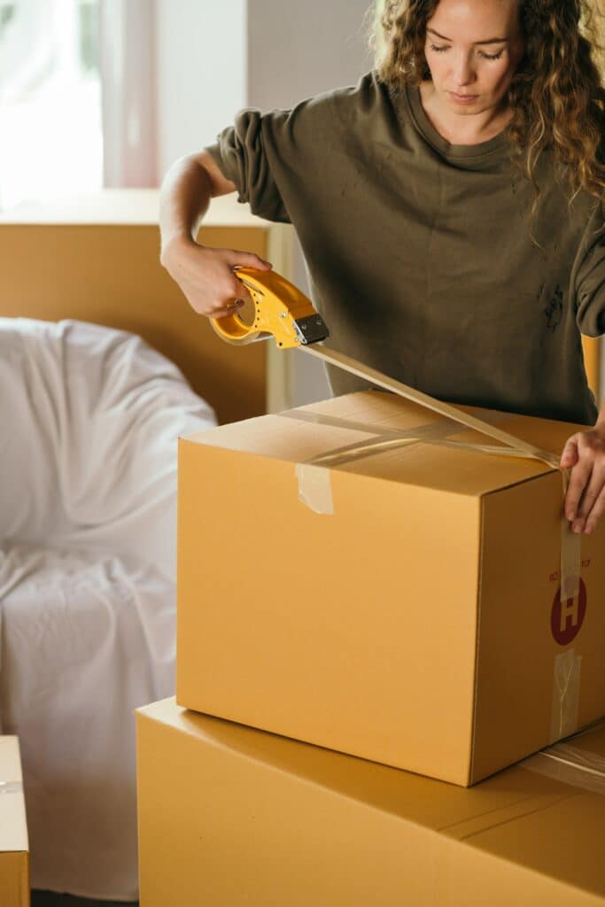 A woman is packing her things in a box.